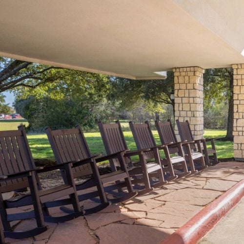 A row of rocking chairs outside of The Waterford at College Station