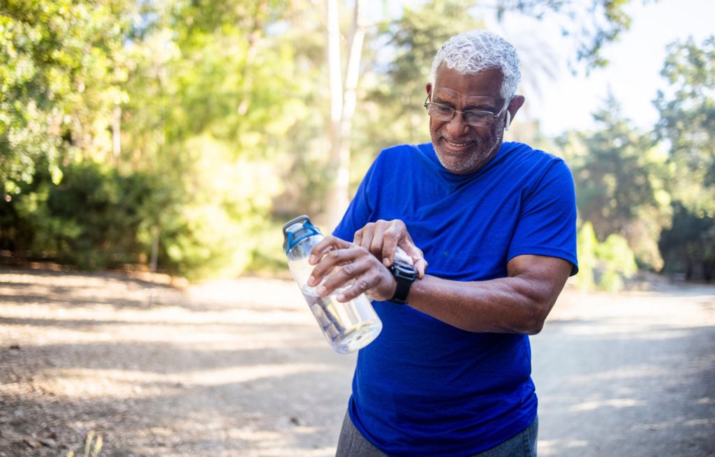 Senior man uses smart watch to track exercise