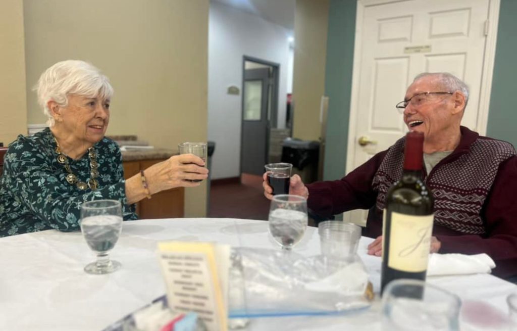 Two residents cheer with red wine over Valentine's Day dinner