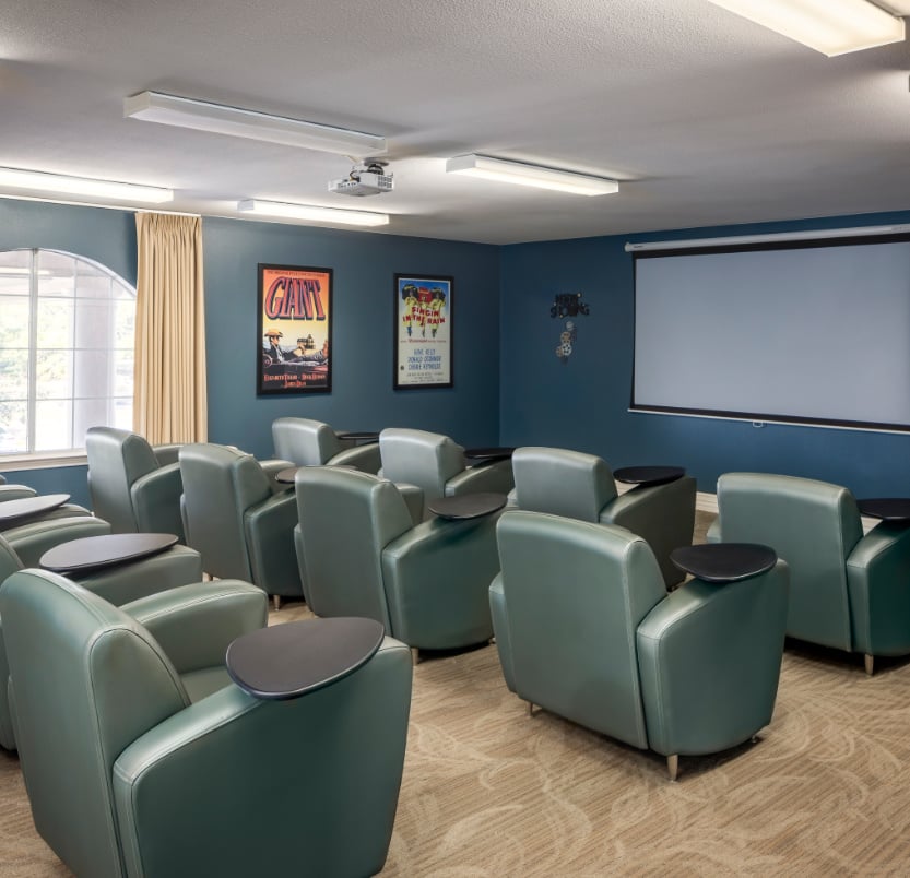 Movie theater room at a senior living community with oversized viewing chairs in Baytown, Texas