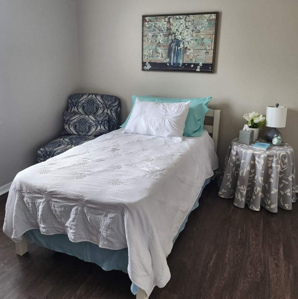 Apartment bedroom with a twin bed, chair, and side table