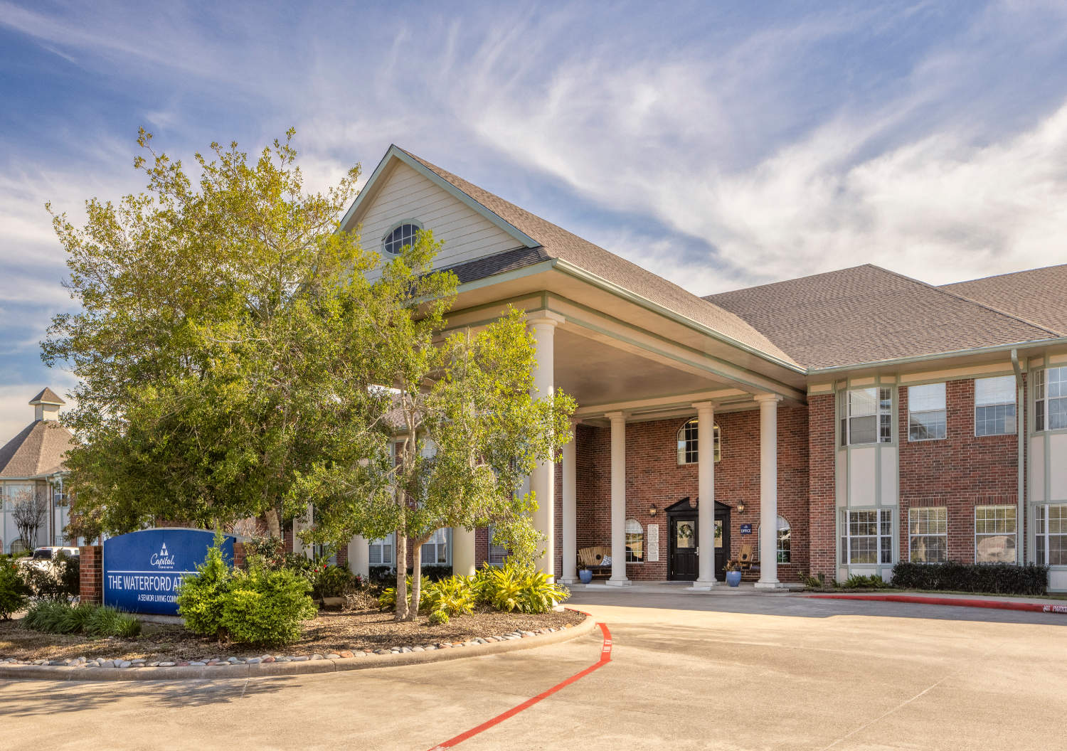 Front entrance to The Waterford at Baytown senior living community with a circular drive in Baytown, Texas