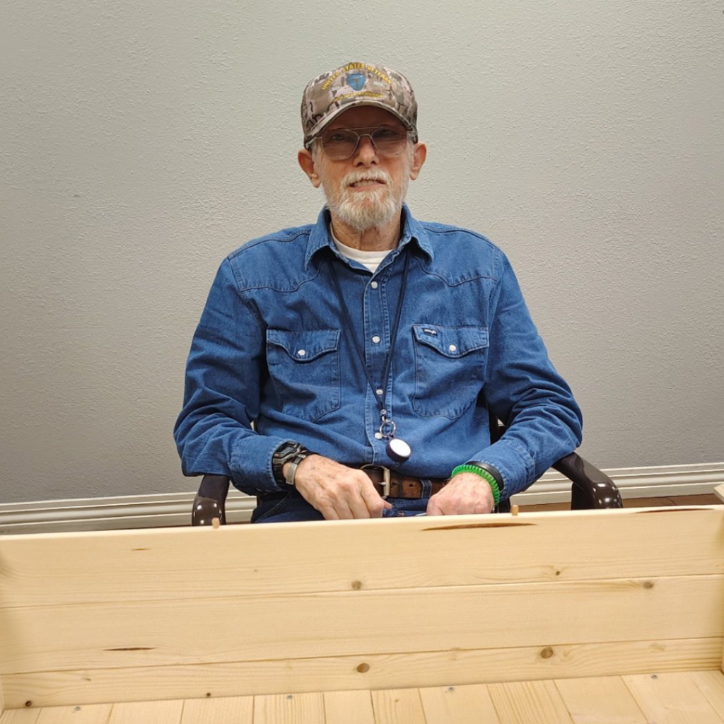 Resident poses behind his craftmanship