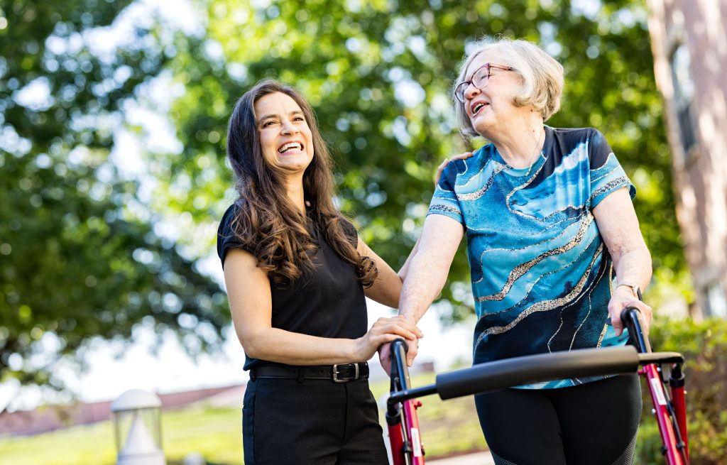 Resident with team member smiling outdoors