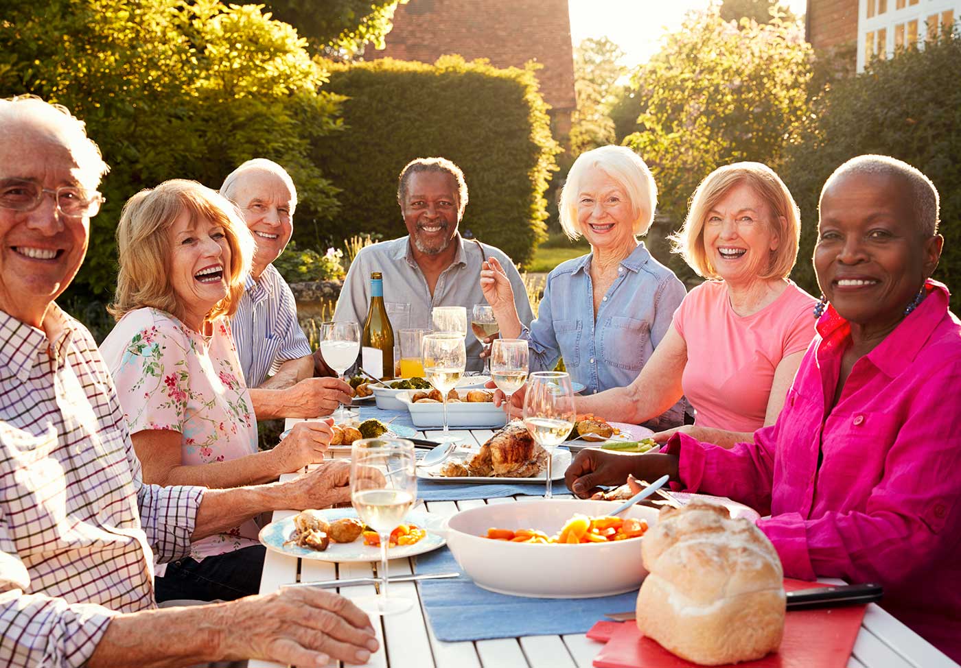 Diverse group of senior citizens enjoying a dinner party with alcoholic beverages