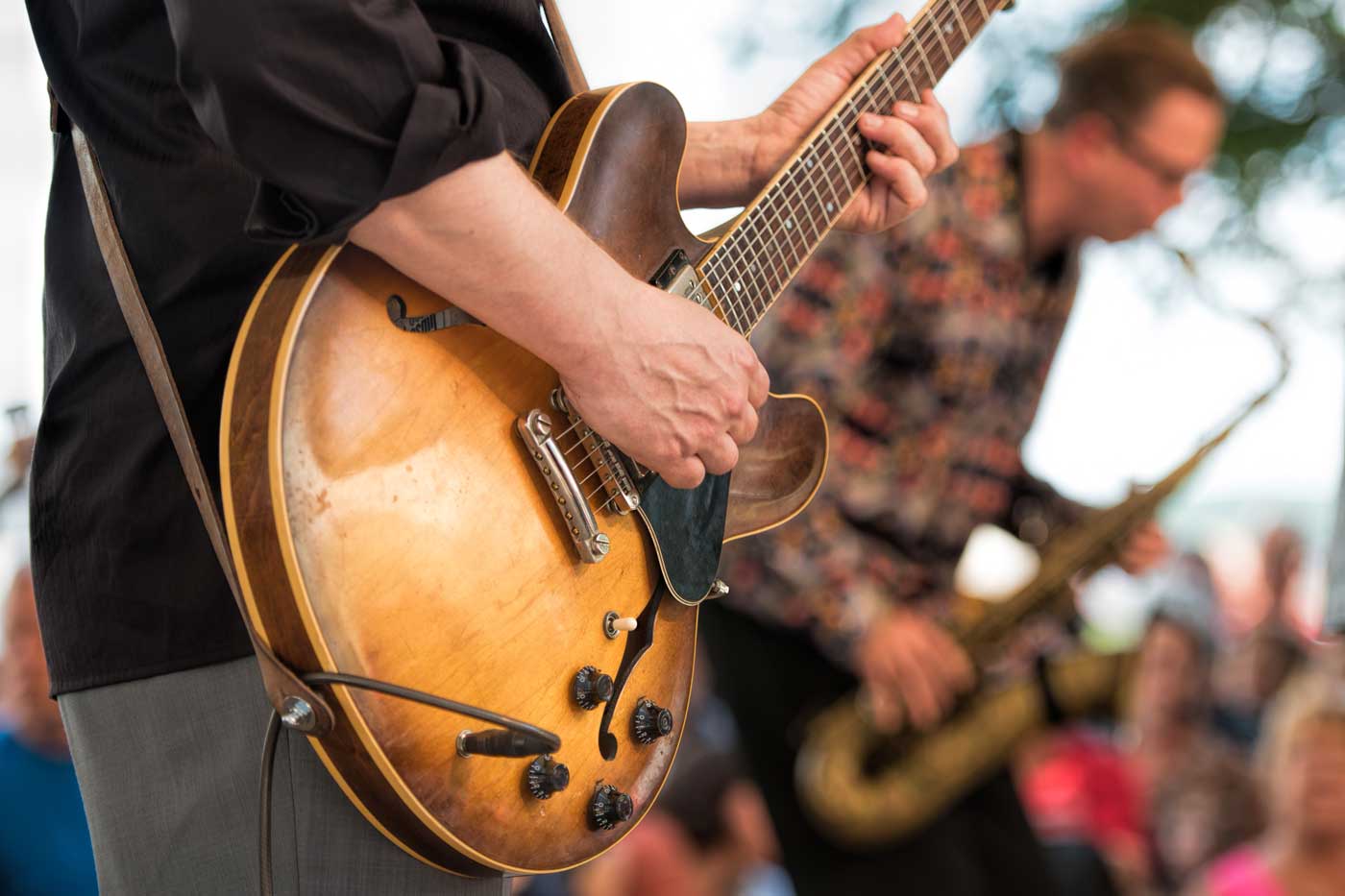 Close up of a band playing live music at an outdoor venue