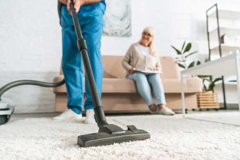 Elderly woman watching as someone else runs a vacuum