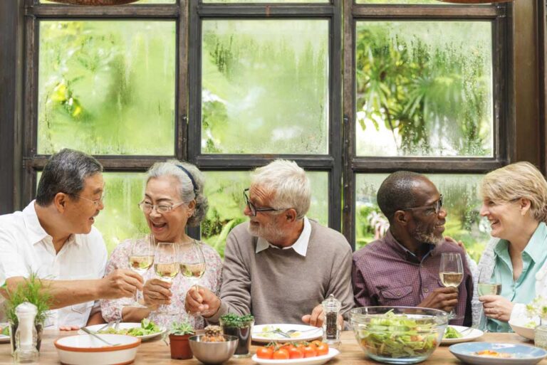 Diverse group of seniors enjoying dinner and cheersing