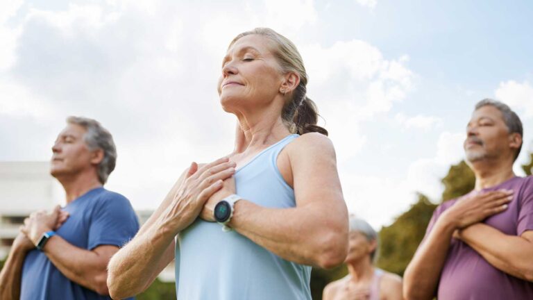 group of elderly people working out together, yoga style