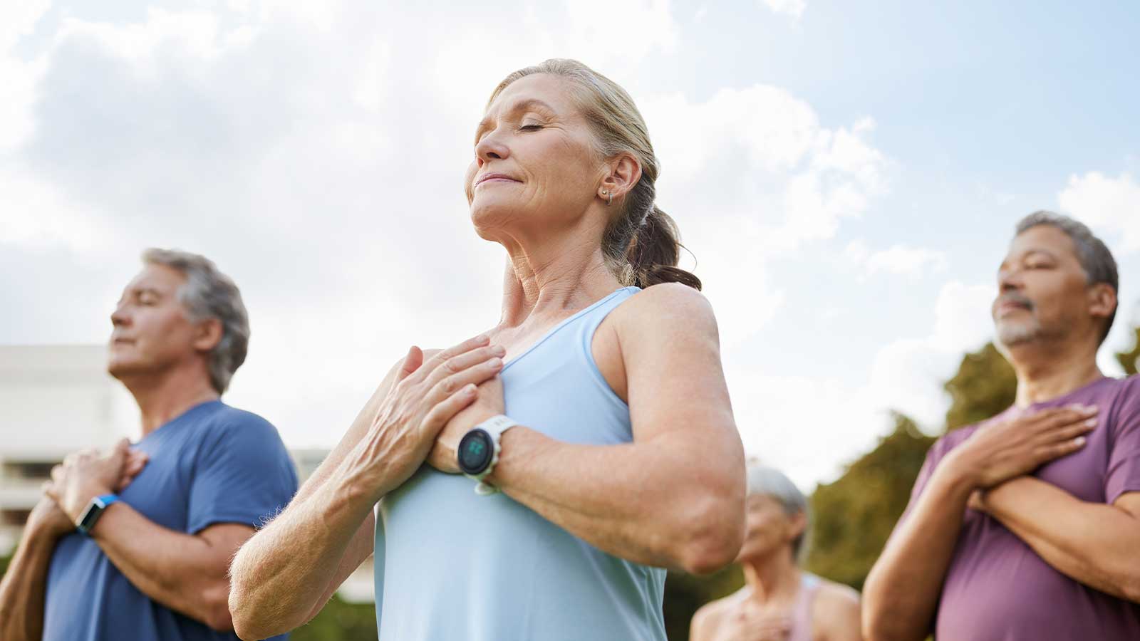 group of elderly people working out together, yoga style