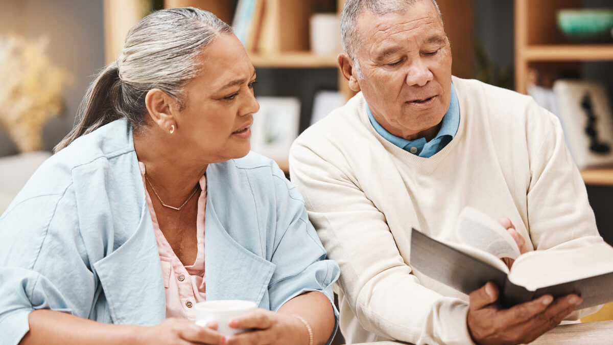 elderly man and woman reviewing a religious text together