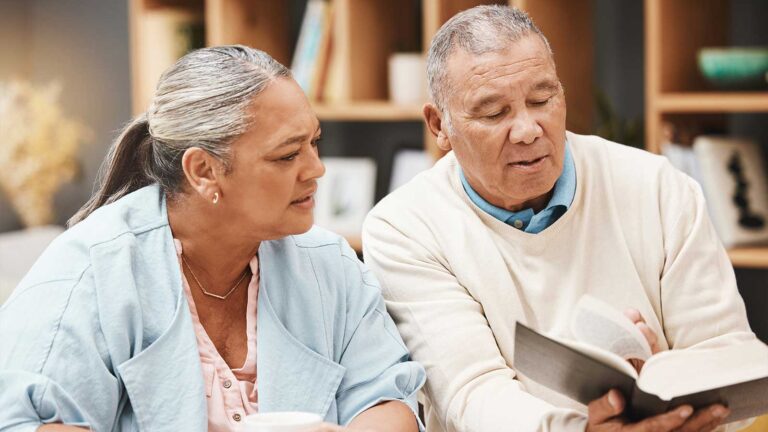 elderly man and woman reviewing a religious text together