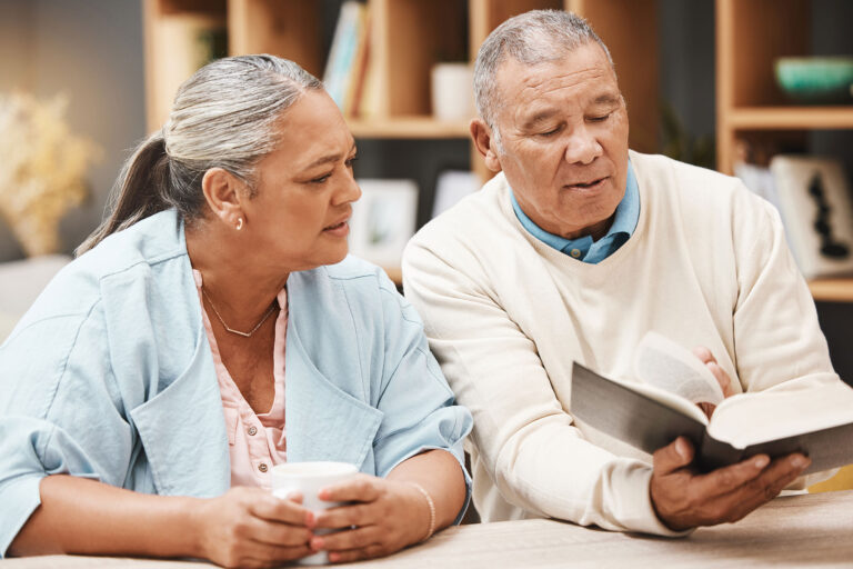 elderly man and woman reviewing a religious text together
