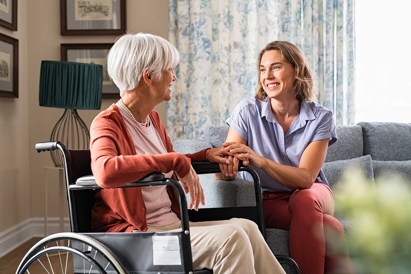 Caregiver interacting with an older woman in a wheelchair