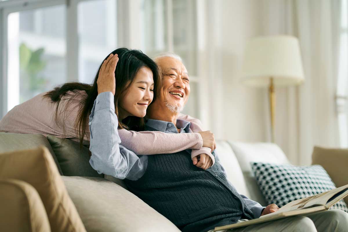Younger woman hugs her elderly father