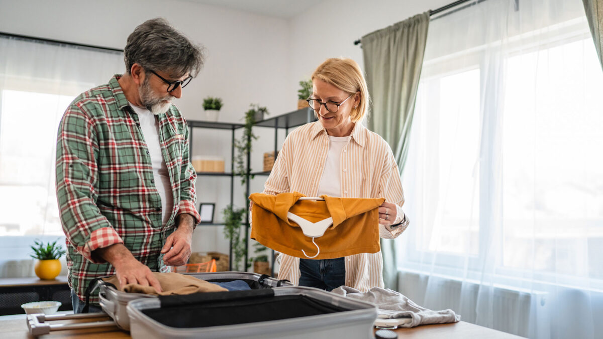 Elderly couple unpacks a suitcase together